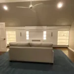 Wide angle view of a custom attic media center installed under a pitched roof in a modern loft.