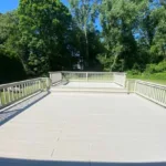 Wide perspective of the main deck platform facing the woods after a full residential deck restoration.